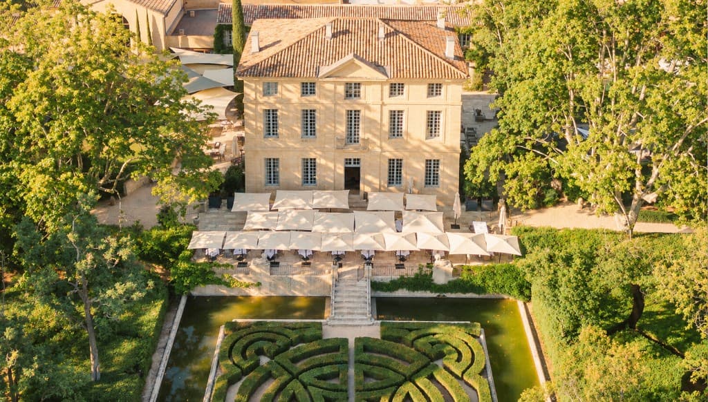 Aerial view of Château de la Gaude with its terrace umbrellas and formal garden
